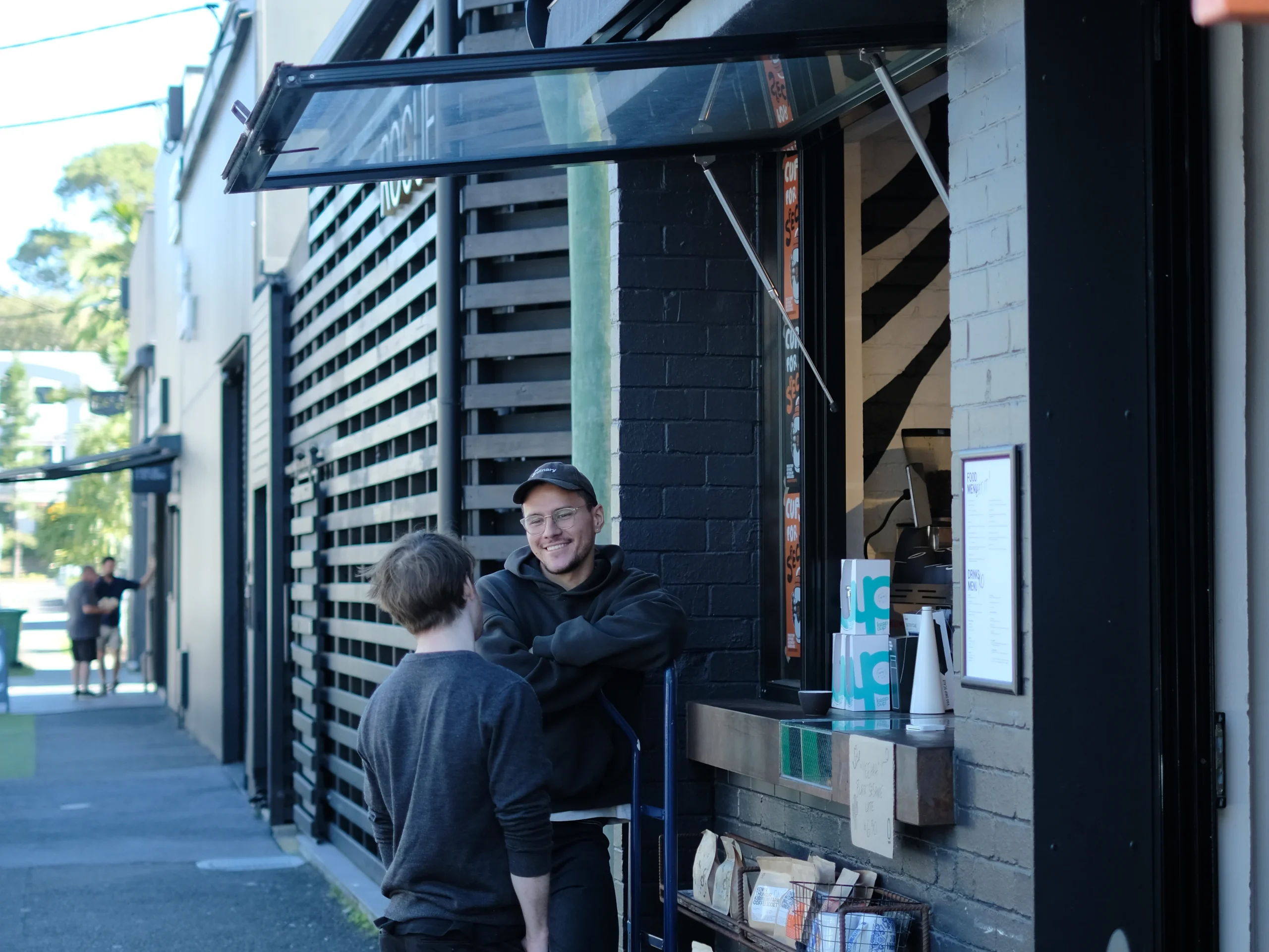 A Milkmen team member chats with a Brisbane cafe owner during a specialty supply delivery