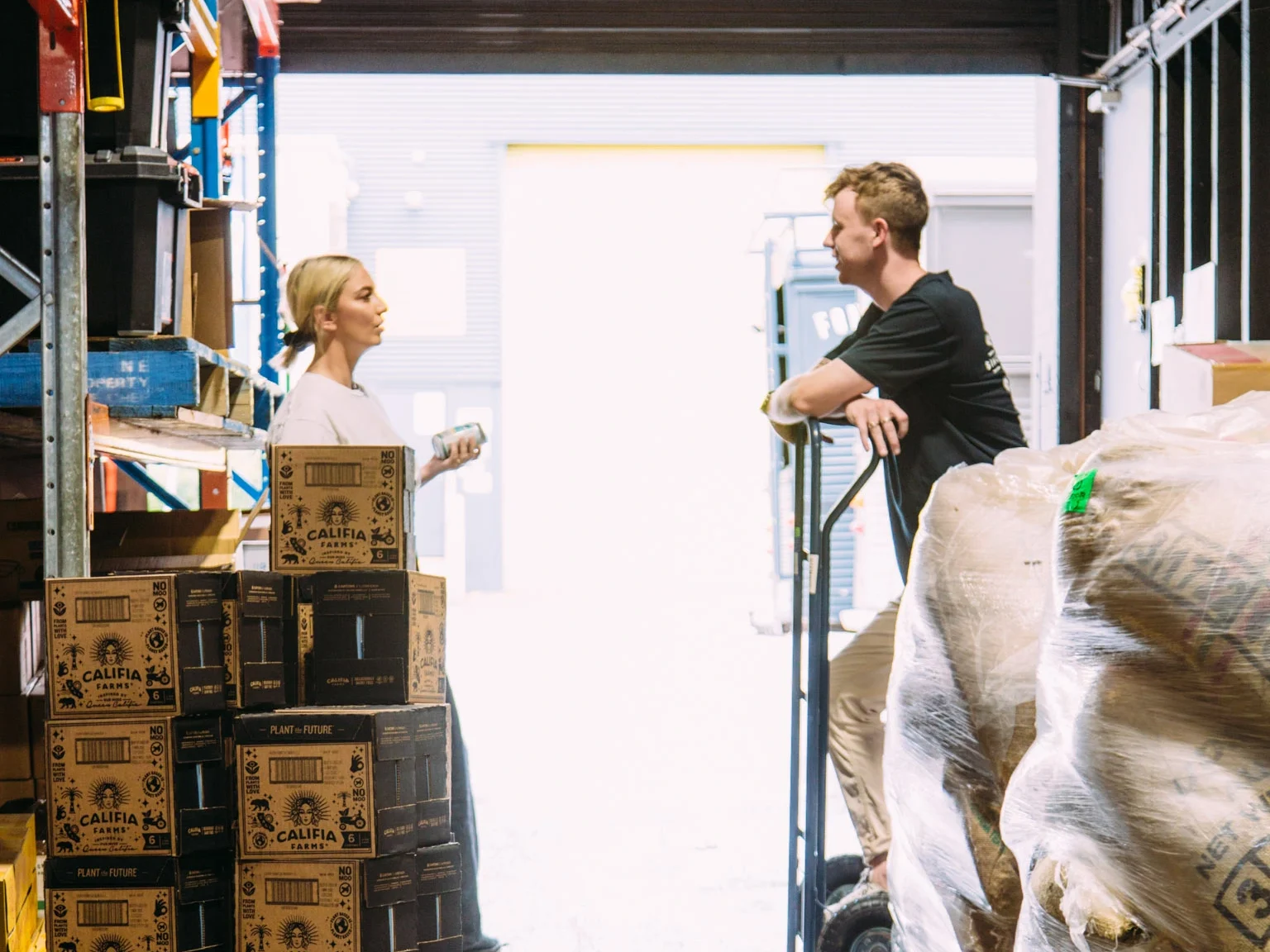 Behind the scenes at the Milkmen warehouse with stacked Califia Farms alternative milk cartons